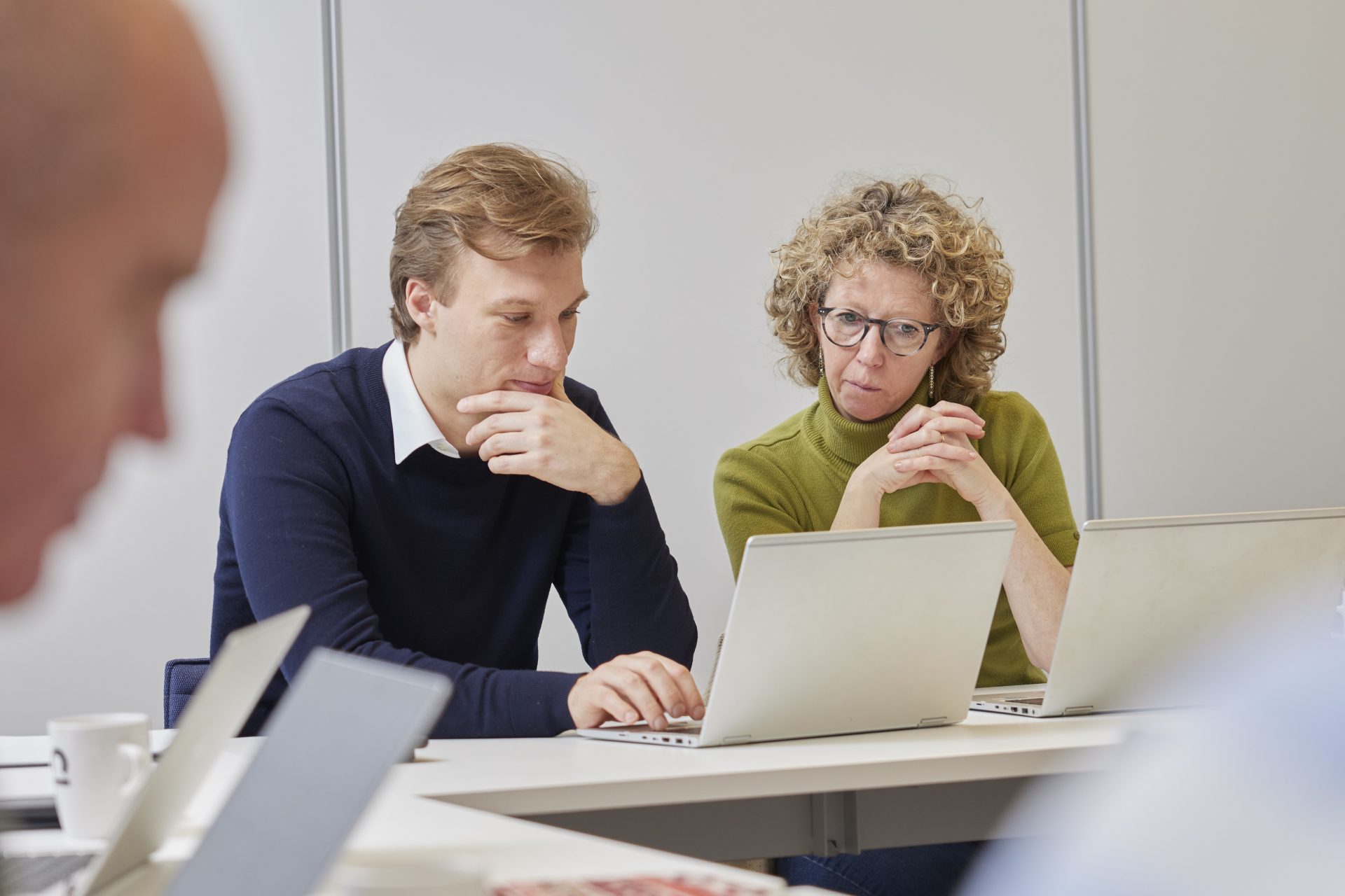Man en vrouw kijken samen op computerscherm in de verdiepingsfase van de leergang basisvaardigheden.